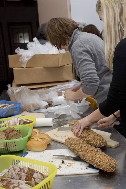 BASF-Mitarbeitende in der Suppenküche beim Portionieren von Brot.  | Foto: Jona-Kirchengemeinde
