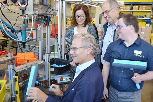 Stolz hält der Verbandsbürgermeister seinen selbstmontierten Scheibenreiniger in Händen. | Foto: Dennis Christmann/Lebenshilfe Südliche Weinstraße