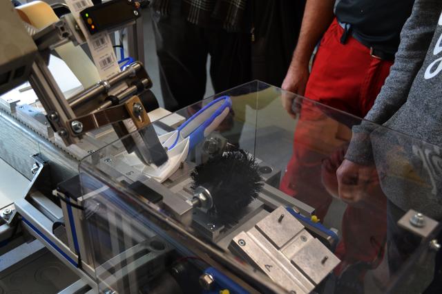 Eine Etikettiermaschine für den 2K-Eisschaber ist nur eines der in der Betriebswerkstatt entwickelten Hilfsmittel, die Menschen mit Behinderung die Teilhabe am Arbeitsleben erleichtern. | Foto: Dennis Christmann/Lebenshilfe Südliche Weinstraße