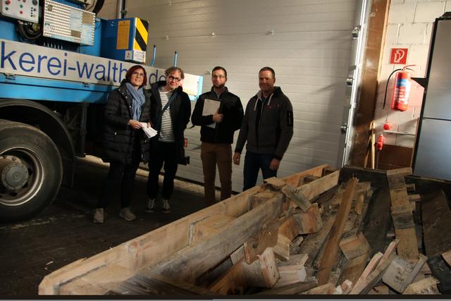 Petra Dick-Walther, Thomas Giel, Jonas Groschke und Ralf Walther erklären die Restholzheizung, mit der die Halle geheizt wird.