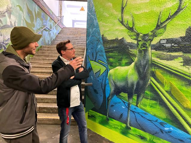 Der Künstler Aaron Zeitz und der Leiter des Projekts beim Bahnhofsmanagement der "DB" in Karlsruhe, Jochen Wagner, schauen sich das fertige Werk an. | Foto: Alessa Becker 