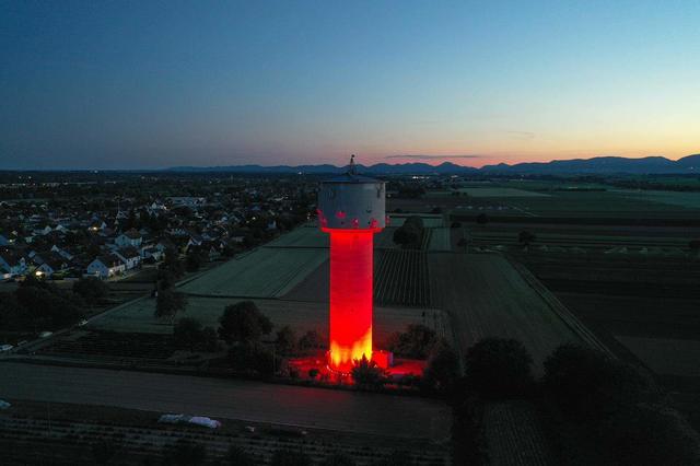 Weit sichtbar strahlt der Wasserturm in Lustadt Montagnacht in Rot | Foto: Megasound Dieter Spirk