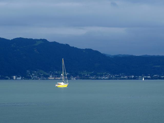 Einsames Boot auf dem Bodensee vor den Bergen von Österreich