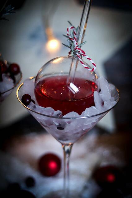 Weihnachtlicher Gin Tonic - serviert in einer Christbaumkugel aus Glas und auf Eis