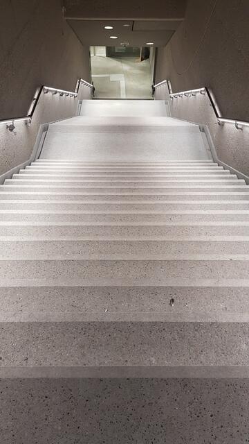 Blick in den Tunnel Karlsruhe: Die Treppen sind aus hellem Material, die Griffe haben Lampen integriert, leuchten nach unten | Foto: www.jowapress.de