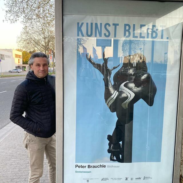 Peter Brauchle neben einem seiner Plakate "Seelenwesen" in Landau | Foto: Frau Brauchle
