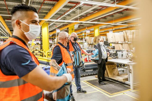 Gemeinsam mit Maaoui Ammar (Amazon Versandmitarbeiter), vielen Amazon-Kollegen und Martin Hebich (Oberbürgermeister der Stadt Frankenthal) packen sie 250 Rucksäcke für bedürftige Kinder. | Foto: Amazon Frankenthal