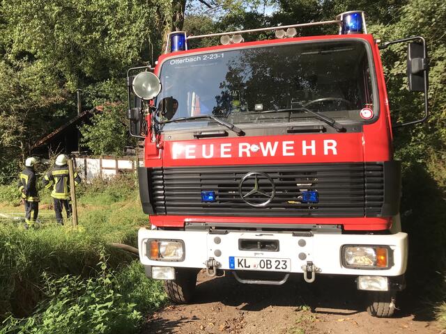 Zwei Feuerwehrangehörige blicken auf das Vereinsheim. Rechts das
Tanklöschfahrzeug der Feuerwehr Otterbach. | Foto: Feuerwehr VG Otterbach-Otterberg