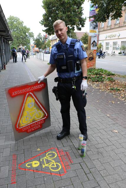 Alexander Lehmann von der AG Fahrrad der Polizei in Speyer sprüht die Symbole auf den Gehweg vor dem Fahrradparkhaus am Hauptbahnhof | Foto: Heike Schwitalla