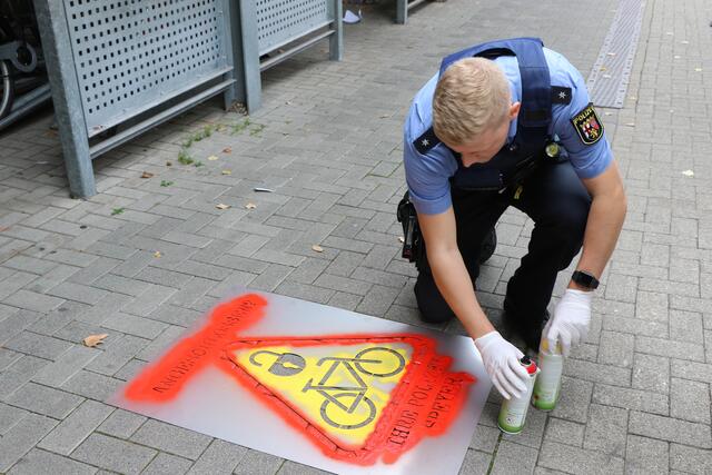 Alexander Lehmann von der AG Fahrrad der Polizei in Speyer sprüht die Symbole auf den Gehweg vor dem Fahrradparkhaus am Hauptbahnhof | Foto: Heike Schwitalla
