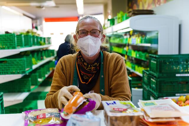 Eine ehrenamtliche Helferin packt Wurst- und Fleischwaren in die Kiste für bedürftige Menschen | Foto: Kim Rileit