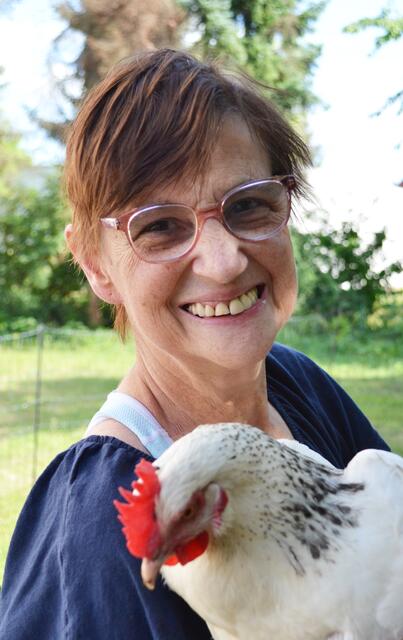 Bewohnerin Silvia Werling genießt es, Huhn Siri auf dem Arm zu halten. | Foto: Dennis Christmann/Lebenshilfe Südliche Weinstraße