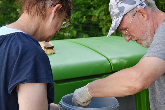 Teamwork: Silvia Werling und Paul Kunz sorgen für frische Streu und reinigen den mobilen Hühnerstall. | Foto: Dennis Christmann/Lebenshilfe Südliche Weinstraße
