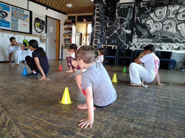Der Capoeira-Trainer Cao zeigt den Kindern im Ferienprogramm die sogenannte „Cocorinha“, eine Ausweichbewegung. | Foto: Dana Graulich