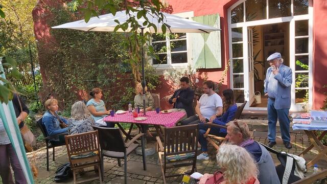 Gäste im Garten, in der Mitte u.a. Dr. Marta Schmidt, Dr. Andrea Menges-Fleig, Parsa Marvi, MdB für Karlsruhe und im weissen Hemd der Komponist Marko Cirkovic mit Ehefrau im blauen Blazer. Stehend Norbert Happel, Stadtbaumeister aD 