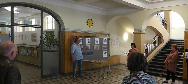Bei der Führung durch die Riedschule: Architekt Claus Lohr erläutert die Fotos, vor der Säule stehend Stephanie Isenböck, im städtischen Hochbauamt die zuständige Projektarchitektin.