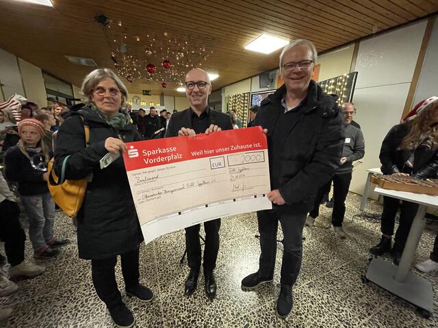 Anke Behres-Kurz und  Clemens Simon nehmen den symbolischen Scheck von Schulleiter Jung (Mitte) entgegen. | Foto: Weiler