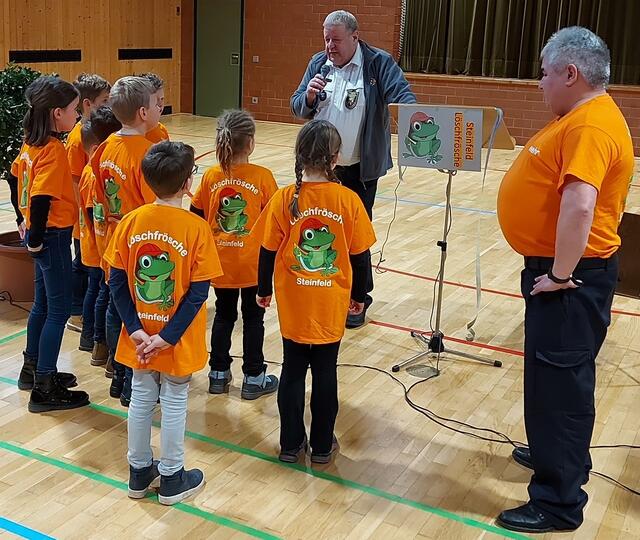 Hans-Georg Balthasar,Vorsitzender des Regionalfeuerwehrverbands (Hintergrund), erklärte den Kindern, was in der Bambinifeuerwehr alles gemacht wird, rechts der Leiter der „Löschfrösche“, Gregor Vogel. | Foto: Freiwillige Feuerwehr Steinfeld