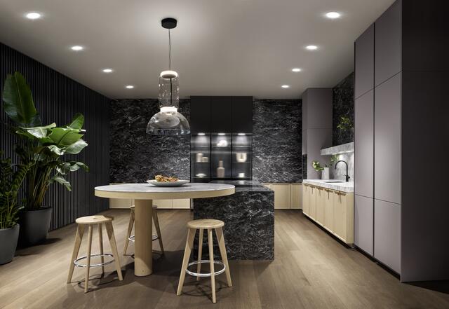 Ausdrucksstark: Die Kochinsel wird von einem dunklen Kalkstein umhüllt. Dazu sind eine extra starke Arbeitsplatte der Spülenzeile und Rahmenfronten in Eiche kombiniert. Foto: VDM/SieMatic | Foto: VDM/SieMatic