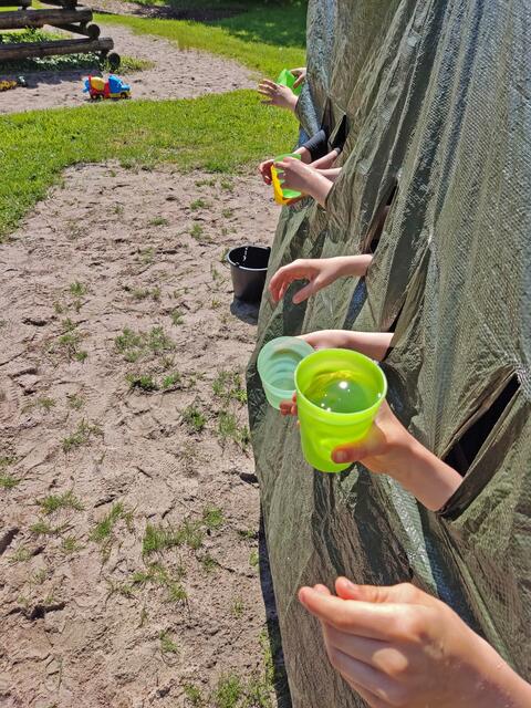 Das Spiel "Wasserbecher durch Plane geben" in Wilgartswiesen. | Foto: C. Daußmann