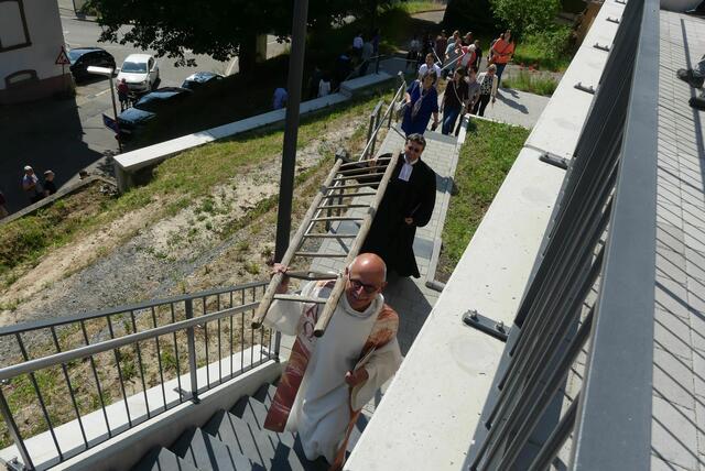 Pfarrer Wolfram Stockinger (vorne) und Pfarrer Klaus Vogel tragen die Leiter von der evangelischen in die katholische Mauritiuskirche am Kopf einer kurzen "Prozession" | Foto: Martin Stock