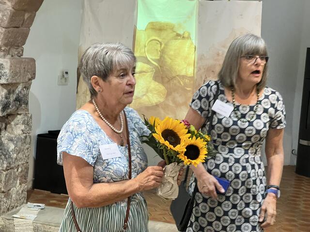 Künstlerin Marian Murphy hält nach der Eröffnung einen Sonnenblumenstrauß neben Künstlerin Karolin Hibbs. | Foto: Z. Haggag