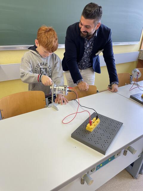 Niclas lernt am Dynamo die Funktionalität des Stromkreises. Physiklehrer Halil Köse erklärt die Zusammenhänge.
 | Foto: Weiler