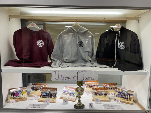 Die „Vitrine of Fame“ mit den Turniersiegern. Oben: die Schulhoodies | Foto: Weiler