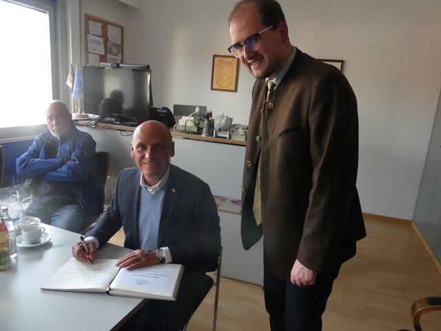 Daniel Born (SPD) trägt sich ins „Goldene Buch“ der Stadt Kraichtal ein im Beisein von Bürgermeister Tobias Borho (SPD, rechts) und Stadtrat Gerhard Scheck (SPD) im Hintergrund | Foto: agentur art