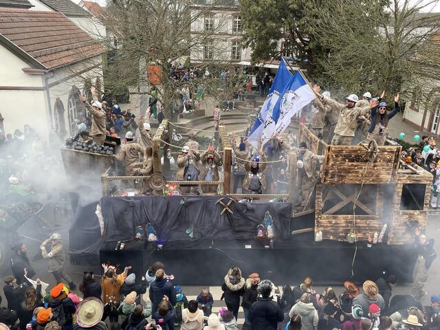 Der Hatzenbühler Faschingsverein mit zwei großen Fahnen und viel Rauch und detailgetreuen Verzierungen am Wagen | Foto: Katharina Schmitt