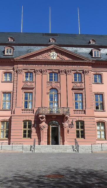 Dies ist der Haupteingang des Deutschhauses mit Plenarsaal. Das Deutschhaus wurde in den Jahren 1729 bis 1740 als Residenz des damaligen Hochmeisters des Deutschen Ritterordens erbaut - zerbomt im 2. Weltkrieg, Danach wurd es 1950/1951 innerhalb von 153 Tagen nach historischen Plänen wieder aufgebaut.
Weil dies so schnell geschafft, musste es später dann noch einmal renoviert werden, um neuen Anforderungen und Vorschriften zu genügen.
Der Bau ist wunderschön und der rote Sandstein leuchtet förmlich in der Sonne. | Foto: Maiken Liefeith