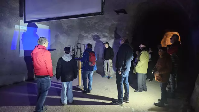 Armin Kupper zeigt den Gästen mithilfe von Bildern eines baugleichen Bunkers, wie es hier einmal hätte aussehen sollen. | Foto: Eva Bender