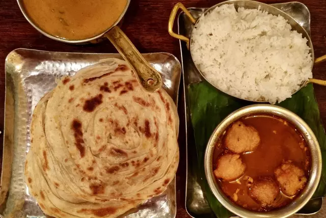 Südindische Küche im Blick: Appam, eine Pfannkuchenart, die in der Regel aus fermentiertem Reisteig und Kokosmilch hergestellt wird - dazu schöne Beilagen mit Reis - in diesem Fall übrigens serviert auf einem Bananenblatt | Foto: © IGNKA