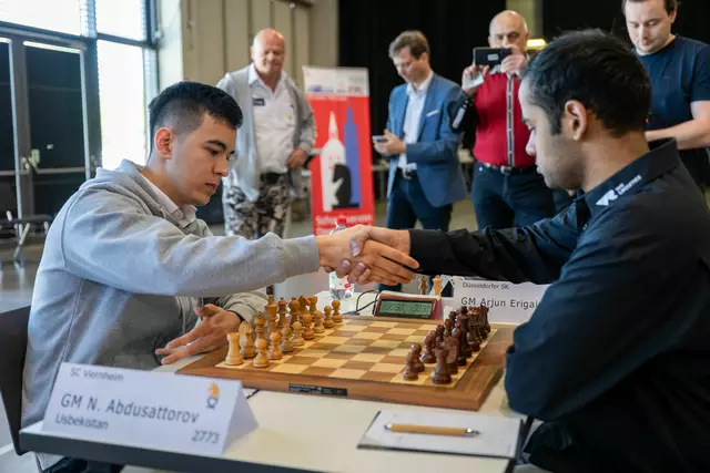 Die Besten des Schachsports zum Greifen nah: Arjun Erigaisi (rechts, Indien, Nummer 4 der Welt) gegen Nodirbek Abdusattorov (Usbekistan, Nummer 6) am ersten Brett beim Vergleich zwischen Meister Düsseldorf und Vizemeister Viernheim. Im Hintergrund links: Team- und Vereinschef Stefan Martin sowie Markus von Rothkirch vom Sponsor d-fine | Foto: Christian Hoffmann