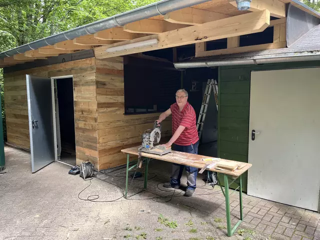 Der Endspurt läuft: Vereinsrings-Vorsitzender Gerd Hach verkleidet die Außenwand des Spülbereichs mit Dielenbrettern | Foto: Tim Altschuck