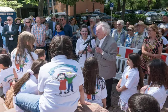Altdekan Friedhelm Borggrefe (am Mikrofon) umringt von Grundschulkindern und Gästen der Feierstunde, links neben ihm Bildhauerin Barbara Rumpf.  | Foto: Prot. Dekanat LU/Wagner 