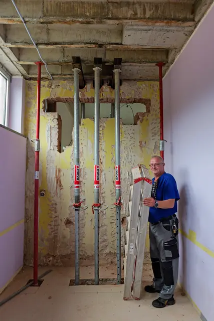 Hausmeister Robin Kupferschläger zeigt den ersten Durchbruch zwischen Alt- und Neubau der Grundschule Moorbachtal – hier verlaufen künftig Kabel- und Rohrverbindungen. | Foto: Erik Stegner