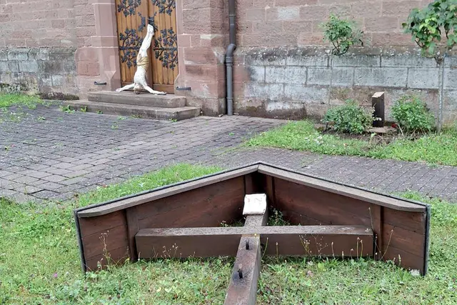 Erschütterndes Bild am Morgen nach der Tat: Das abgesägte Missionskreuz liegt im Gras, die Christusfigur wurde mit dem Kopf nach unten vor der Kirchentür der St.-Valentinuskirche abgelegt. Laut Polizei handelt es sich um vorsätzlichen Vandalismus – Zeugen werden dringend gesucht. | Foto: Richard Roschel