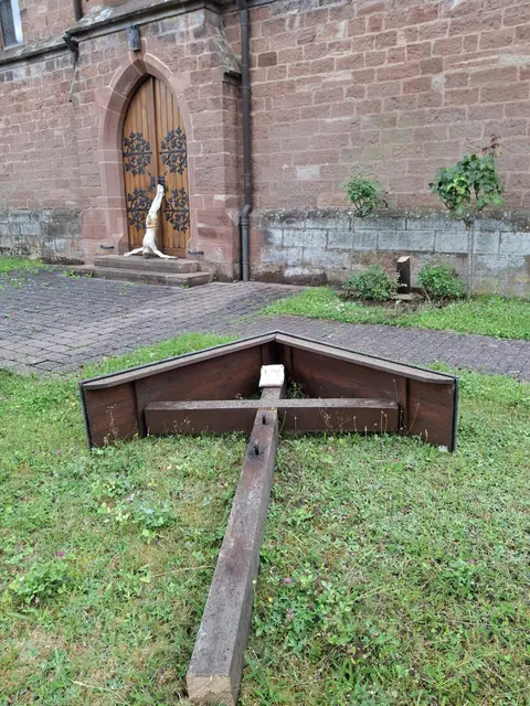 Schockierende Szene vor der St.-Valentinuskirche: Das massiv abgesägte Missionskreuz liegt im Gras, die Christusfigur wurde von den Tätern mit dem Kopf nach unten an der Kirchentür abgelegt. Die Polizei ermittelt wegen gemeinschädlicher Sachbeschädigung und bittet um Hinweise. | Foto: Richard Roschel