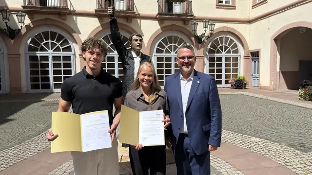 Lilly Dahlke vom Käthe-Kollwitz-Gymnasium (Mitte) und Simon Beneke, Absolvent an der BBS Neustadt wurden von Oberbürgermeister Marc Weigel mit dem Demokratie- und MINT-Preis ausgezeichnet. | Foto: Stadt Neustadt