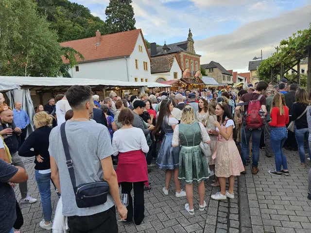 Wildes Getümmel an der Pergola: Nach der Eröffnungszeremonie und dem Stellen des Kerwebaums, verteilen die Haardter Weinhoheiten mit Unterstützung den berühmten „Riesen-Quetschekuche“ und Freiwein vom Fass. | Foto: Eva Bender