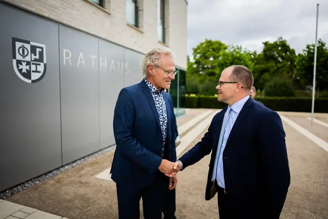 Bundesumweltminister Carsten Schneider (r) und Bürgermeister Axel Wassyl, begrüßen sich beim Besuch des Nahwärmenetzes in Offenbach an der Queich. Bundesumweltminister Schneider bereist bei seiner Pressereise zwei Tage lang Rheinland-Pfalz mit Stationen beim Daimler Truck-Werk, einem Bio-Winzer und BASF. | Foto: Christoph Soeder