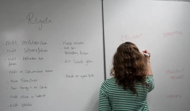 Eine Mitarbeiterin füllt eine Tafel mit gemeinsam erarbeiteten Regeln und Begriffen aus. | Foto: Bildrechte: DHBW KA//DI