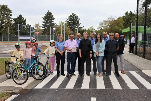 Bürgermeister Lukas Hartmann (vordere Reihe, 3. v. r.) und Beigeordnete Lena Dürphold (vordere Reihe, 2. v. r.) gemeinsam mit Vertreterinnen und Vertretern von Stadtverwaltung, Polizei und Schulgemeinschaft bei der Einweihung der neuen Jugendverkehrsschule | Foto: Stadt Landau