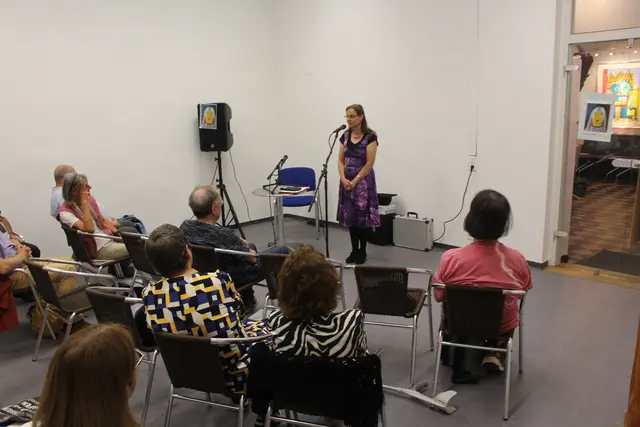 Birgit Heid während einer Ansprache. Links und rechts sind Bilder der japanischen Künstlerin Yayoi Kusama zu sehen. | Foto: Peter Herzer