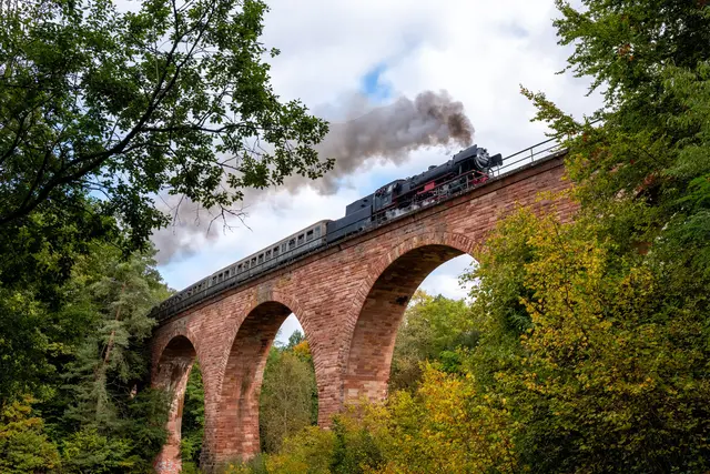 Die historische Dampflok 23 058 überquert das Sandsteinviadukt auf der Biebermühlstrecke hinauf nach Pirmasens – ein beeindruckendes und zugleich seltenes Schauspiel im Rahmen des Jubiläums „150 Jahre Bahnlinie Landau–Zweibrücken“. | Foto: Erik Stegner