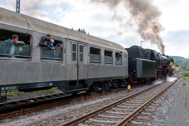 Faszination Eisenbahn: Neugierige Reisende lehnen sich aus den Fenstern, um die Dampflok 23 058 bei der Ausfahrt aus Pirmasens Nord aus nächster Nähe zu erleben. | Foto: Erik Stegner