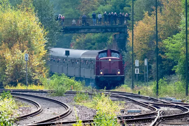 Die historische Diesellok V 100 1019 auf der Biebermühlstrecke bei Pirmasens – auf der Brücke beobachten zahlreiche Schaulustige die Vorbeifahrt des Nostalgiezugs. | Foto: Erik Stegner