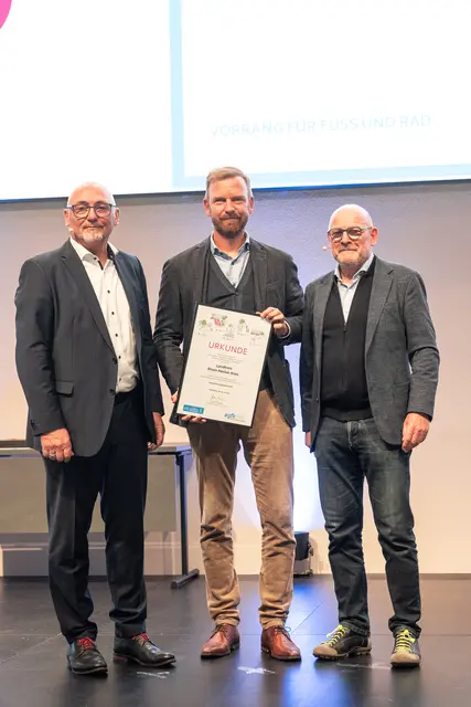 Der im Landratsamt Rhein-Neckar-Kreis für Mobilität zuständige Dezernent Dr. Christopher Leo (Mitte) erhielt von Verkehrsminister Winfried Hermann (rechts) und dem AGFK-Vorstandsvorsitzender Günter Riemer (links) die Urkunde überreicht.
 | Foto: AGFK BW/Susanne Lencinas