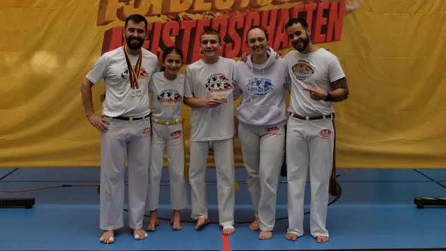Alexis Loucopoulos (Mangalô, Mitte), 1. Platz in der Jugendkategorie, und Alfred Xhelilaj (Graduado Calopsita, links), 2. Platz seiner Kategorie, mit ihrem stolzen Trainer Luiz Carlos dos Santos Gomes (Professor Cao, rechts). Joana Loucopoulos (Amora, 2. v.l.) und Paula Hacker (Graduada Jacarandá, 2. v.r.) erreichten beide das Halbfinale. | Foto: Uwe Böse